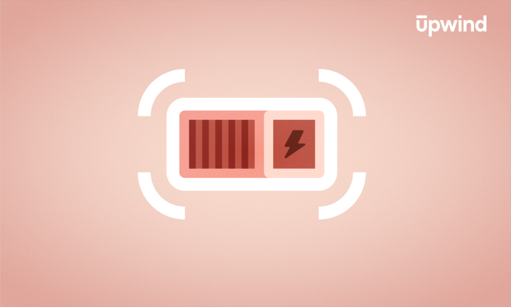 Illustration of a partially charged battery icon with a red level indicator and a lightning bolt symbol against a soft pink background. The word Upwind appears in the top right corner, subtly hinting at the energy flow akin to discussing, What is Container Runtime Interface?.